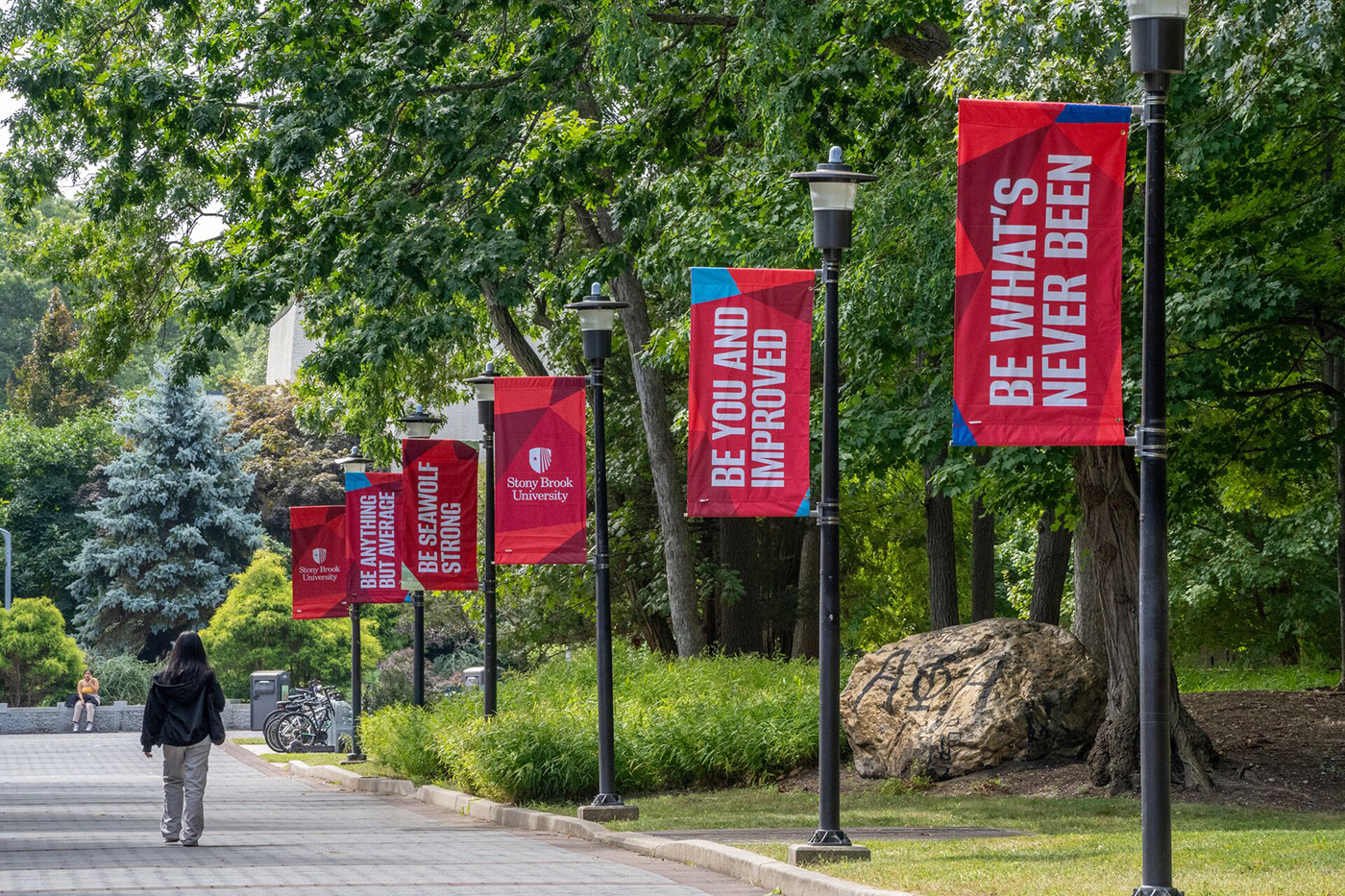 Motivational banners on SBU's campus with messages like "Be what's never been" and "Be you and improved"