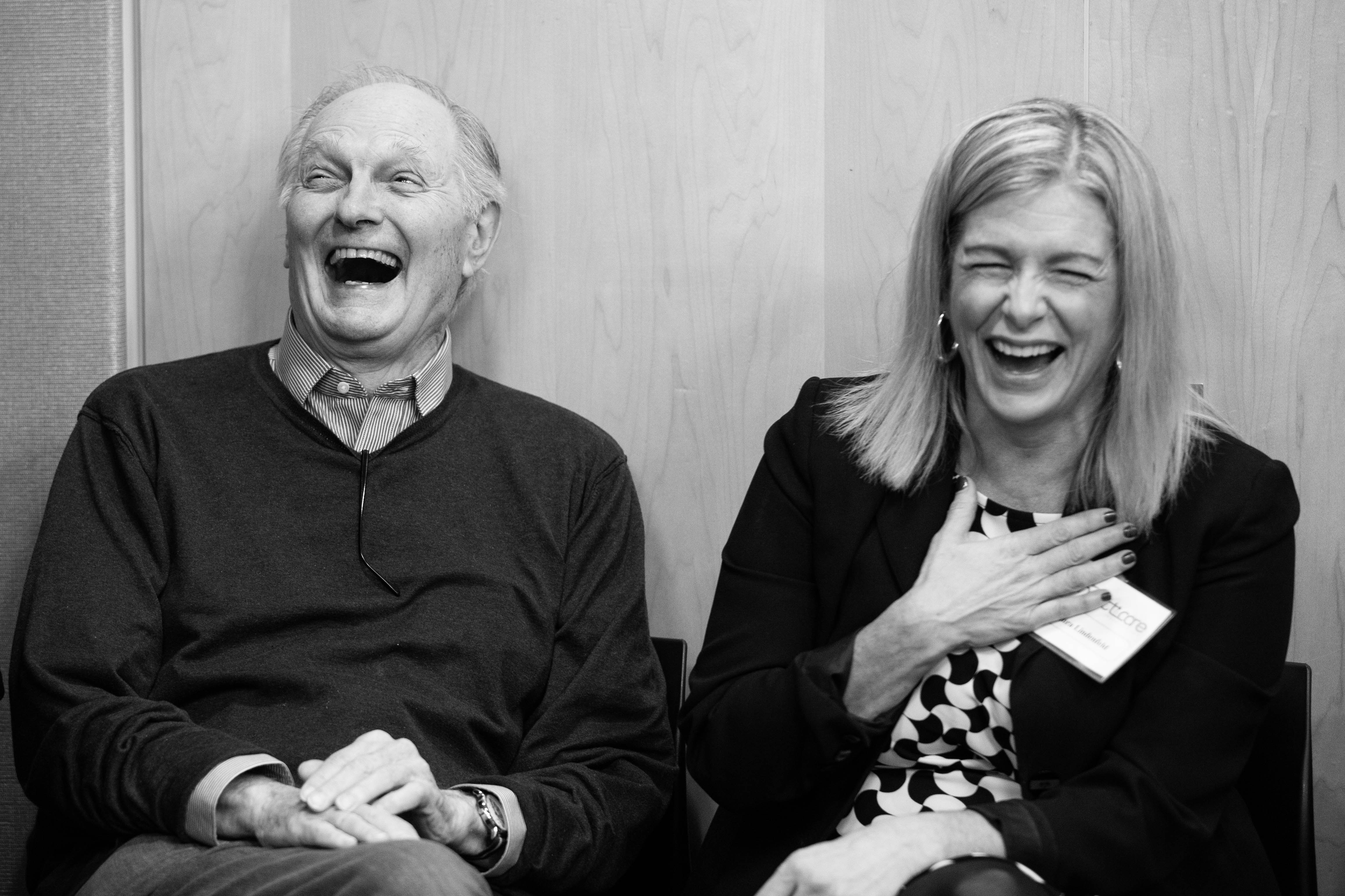 Black and white photo of Alan Alda and Laura Lindenfeld laughing