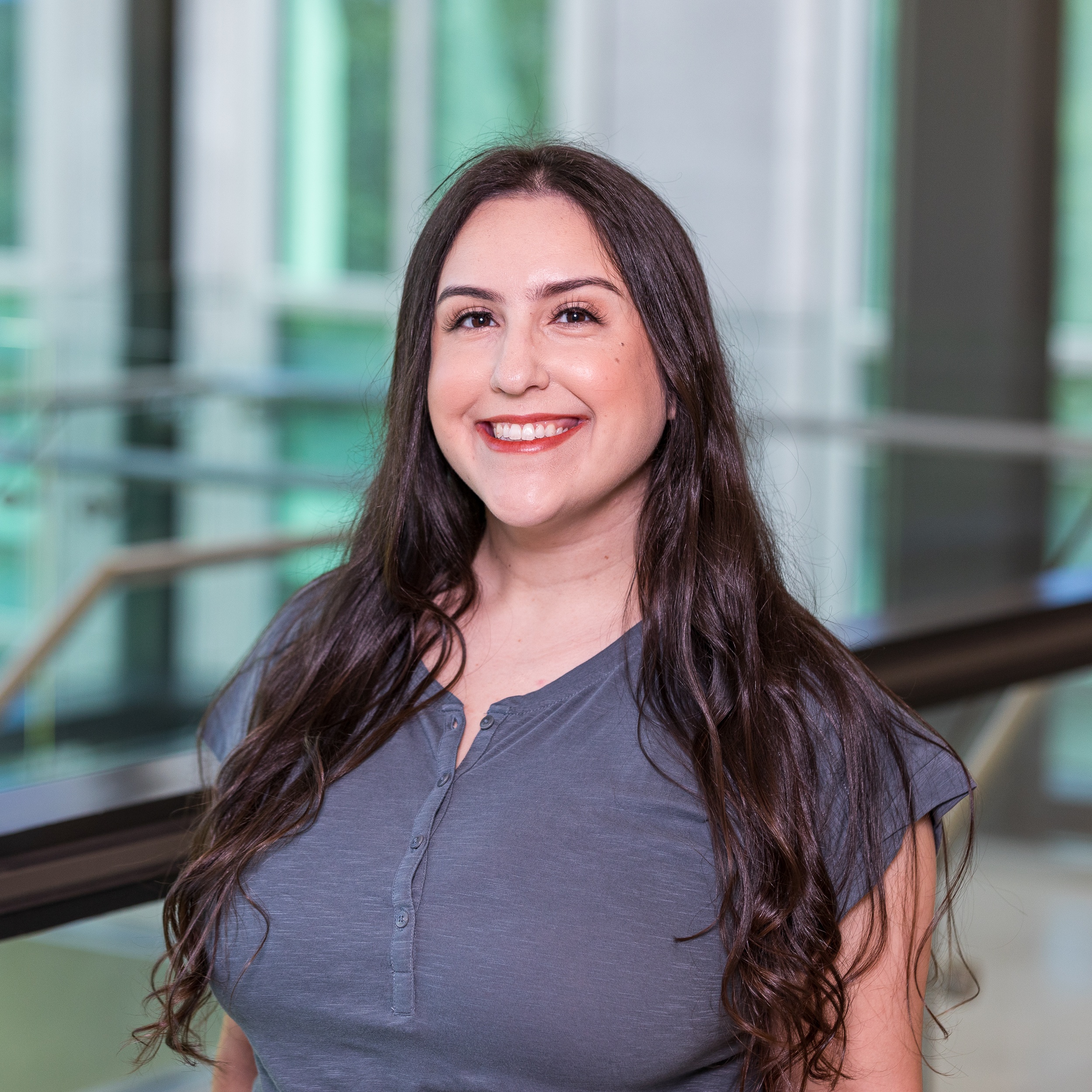 Jennifer bowers Person smiling in a professional setting with a modern glass background.