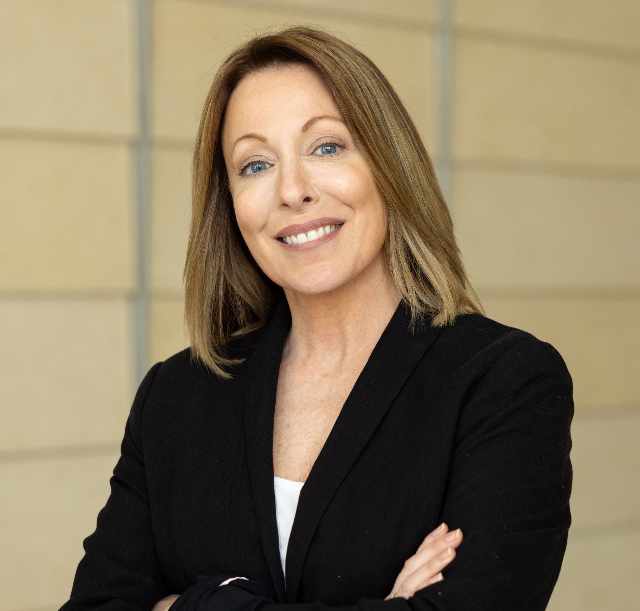 Candice Alfano Portrait of a professional in a black blazer, smiling confidently at the camera.