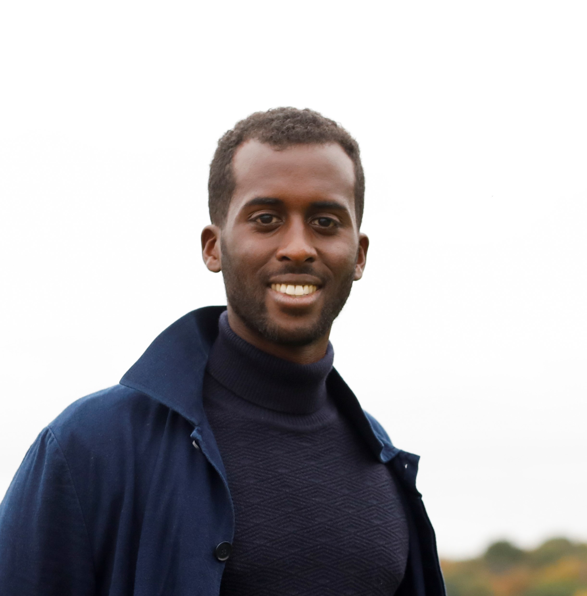 Guleed Ali  Male wearing a Blue coat poses outdoors