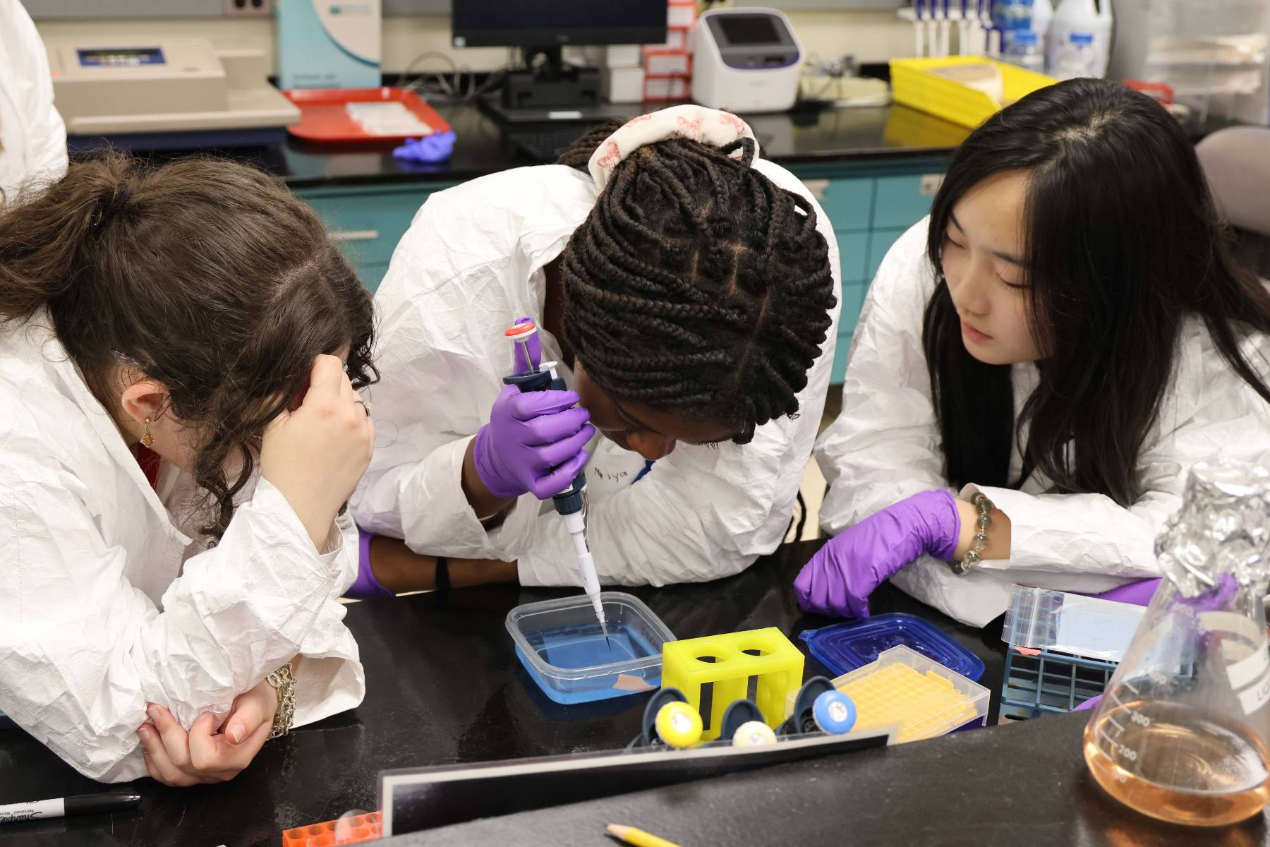 A group of three students working on a project in the cancer bio lab