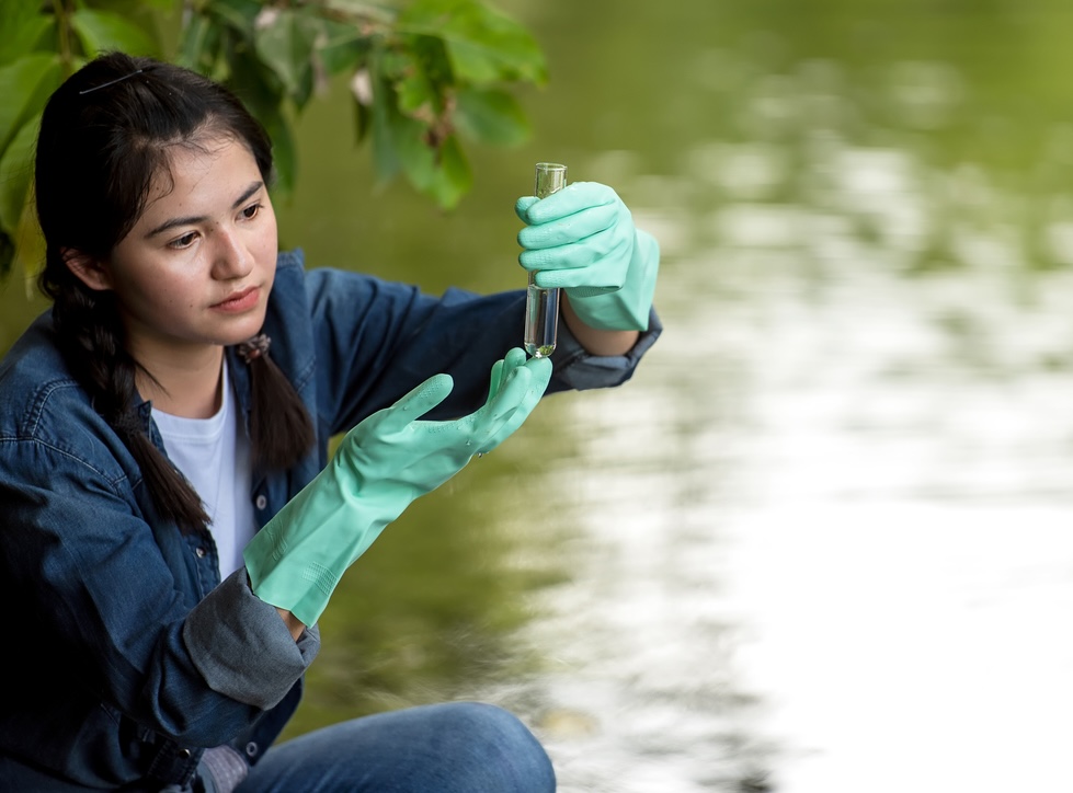 A PCS participant gathering water in a vial for pH testing